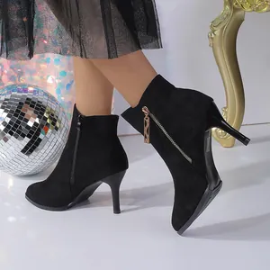 Detailed view of black suede pointed-toe ankle boots with side zipper and stiletto heel
