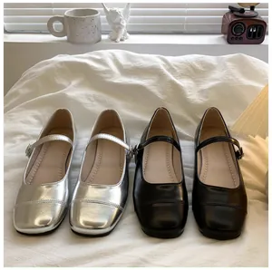 Close-up of stylish silver and black Mary Jane princess shoes for girls on white background.