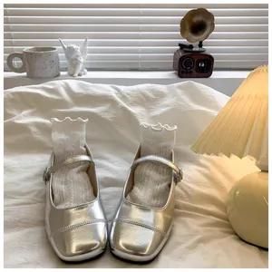 Detailed view of silver metallic Mary Jane princess shoes for girls with lace socks.