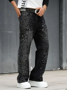 Détail d'un jean noir ample pour homme avec des motifs de feux d'artifice en strass