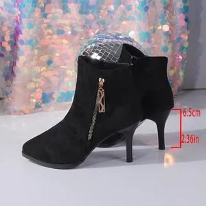 Close-up of black suede pointed ankle boots with 6.5cm stiletto heel detail.