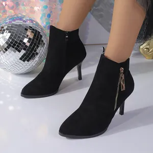 Close-up of black faux suede stiletto ankle boots with elegant gold-tone zipper detail
