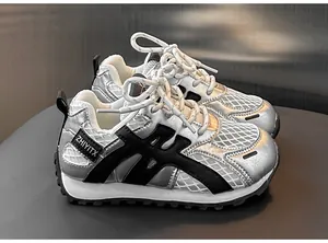 Detail view of silver kids sneakers featuring breathable mesh panels and black side stripes