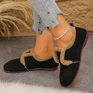 Détail de chaussures plates noires chaudes avec doublure en fausse fourrure beige.