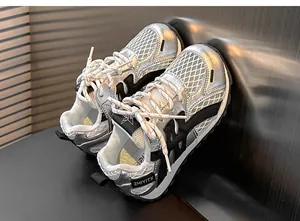 Detailed view of kids' silver metallic sneakers with breathable white mesh.