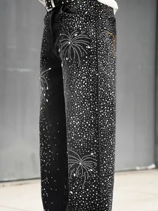Vue détaillée du jean ample pour homme avec un motif complexe de feux d'artifice en strass.