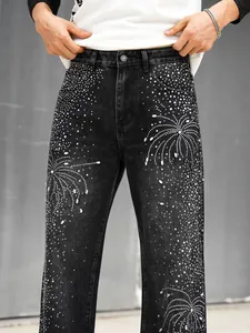 Gros plan sur les motifs complexes en strass et perles d'un jean en denim noir.