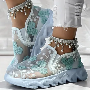 Detailed view of breathable mesh sneakers with elegant teal floral embroidery and platform soles