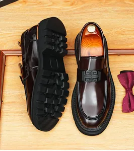 Primer plano de mocasines de cuero brillante para hombre con suela gruesa y hebilla decorativa