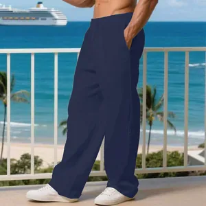 Vista dettagliata dei pantaloni larghi in lino blu navy da uomo su un balcone al mare