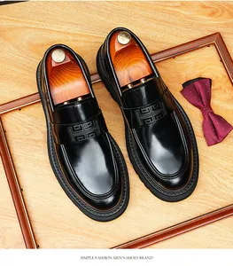 Primer plano detallado de mocasines de cuero negro brillante con un patrón H único en la tira frontal.