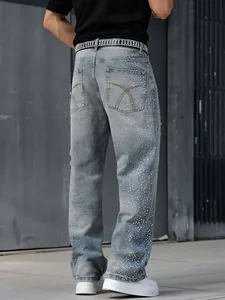 Détail d'un jean droit ample pour homme avec des décorations en strass et perles brillantes