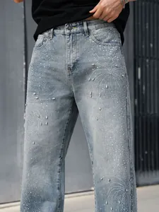 Détail d'un jean coupe droite ample pour homme avec motifs décoratifs en strass brillants