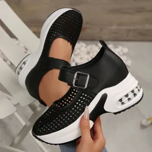 Detail shot of breathable black mesh platform sneakers with wedge heel and buckle.