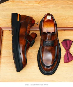 Vista superior de mocasines de cuero brillante marrón con hebilla negra elegante