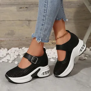 Close-up of black breathable mesh platform sneakers with white chunky soles and buckle strap
