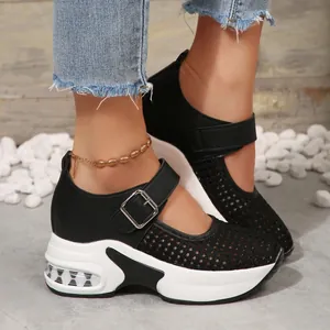 Close-up of women's breathable mesh platform sneakers with buckle strap and air cushion.