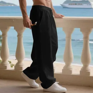 Vista laterale dei pantaloni larghi in lino nero da uomo su un balcone tropicale sul mare