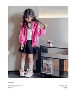 Petite fille élégante portant des chaussures blanches avec fleurs en ruban rose
