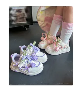 Gros plan sur baskets blanches fille avec fleurs tulipes 3D et lacets en ruban soyeux