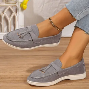 Comfortable grey suede flat loafers for women featuring soft soles and stylish tassel rings