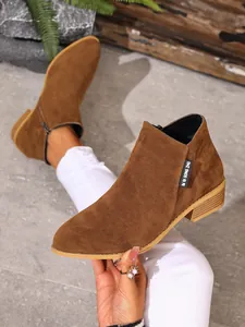 Detailopname van bruine suède Chelsea boots met een handige zijrits en stevige blokhak