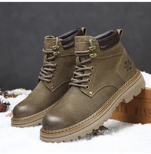 Eine Detailansicht klassischer brauner Outdoor-Arbeitsstiefel auf künstlichem Schnee.