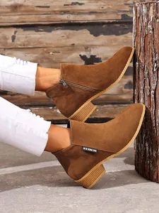 Detail van bruine suède Chelsea boots met een zijrits en een stevige, middelhoge blokhak