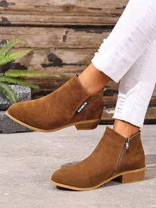 Detailopname van bruine suède Chelsea boots met zijrits en een elegante puntige neus