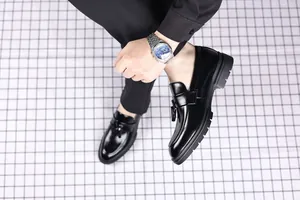 Mens black leather tassel loafers business casual slip-on shoes on grid background