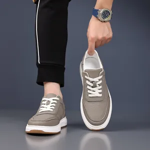 Baskets décontractées en cuir gris haut de gamme pour hommes avec semelle blanche et lacets.