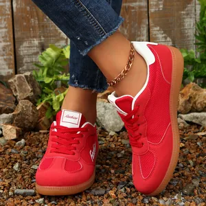 Detailansicht der roten Retro-Sneaker im GAT-Stil für Damen auf kiesigem Boden.