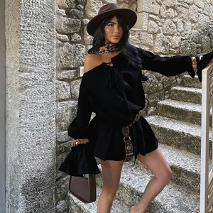 Detail shot of black off-the-shoulder dress with bell sleeves in outdoor setting.