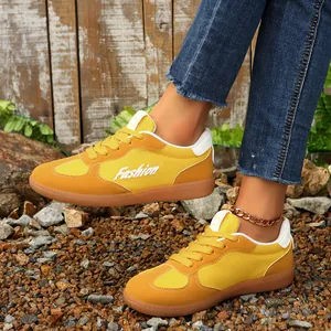 Detailansicht gelber Retro-Sneaker aus Mesh mit Gummisohle auf steinigen Pfaden