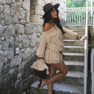 Detail view of khaki off-shoulder dress with lace-up front and bell sleeves on a model