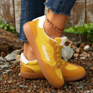 Detailaufnahme gelber Retro-Mesh-Sneaker mit weißen Akzenten im Freien
