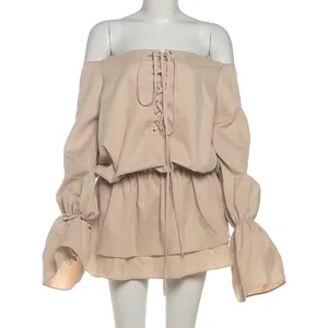 Detailed view of the off-the-shoulder neckline and lace-up front of the beige dress