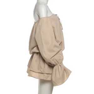 Side view of an off-shoulder beige mini dress with bell sleeves and tie detail