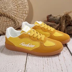 Nahaufnahme von gelben Retro-Turnschuhen mit atmungsaktivem Mesh und Wildleder