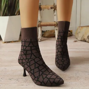 Macro view of brown and black geometric patterned pointed toe elastic fabric sock boots