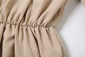 Close-up of elasticated waist detail on khaki off-shoulder flared sleeve dress.