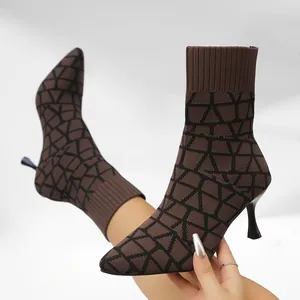 Detailed view of brown pointed-toe sock boots with geometric knit pattern and slim heel.