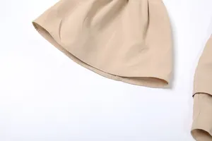 Detailed view of the flared bell sleeve stitching on a beige solid color elegant dress