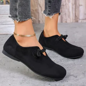 Elegantes mocasines de ante negro para mujer con un detalle de nudo decorativo muy moderno