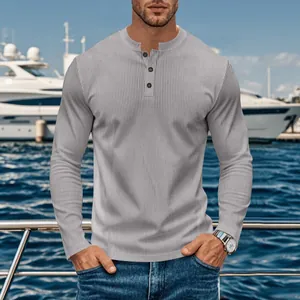 Close-up of a grey ribbed long sleeve Henley shirt on a model in a yacht marina