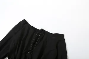 Macro view of black off-the-shoulder dress collar featuring silver eyelet lace-up detail.