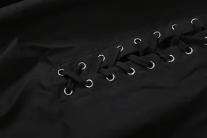 Close-up detail of sexy black off-shoulder dress featuring silver eyelets and lace-up ties
