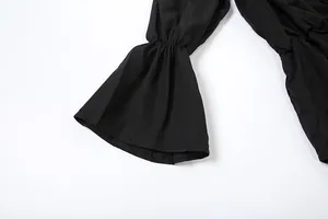 Close-up of the elegant black bell sleeve detail on a solid color dress for autumn fashion