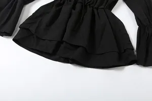 Detail shot of black off-shoulder dress featuring ruffle hem and bell sleeves details.