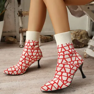 Close-up of white pointed toe stretch ankle boots with elegant red geometric pattern
